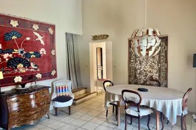 a dining room with a table and chairs and a chandelier at La Maison Rose in LʼIsle-sur-la-Sorgue
