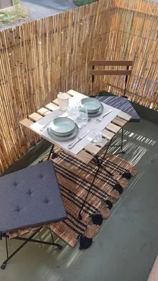a picnic table with plates and glasses on a patio at Le Colibri - studio paisible et raffiné au sud d'Aix in Aix-en-Provence