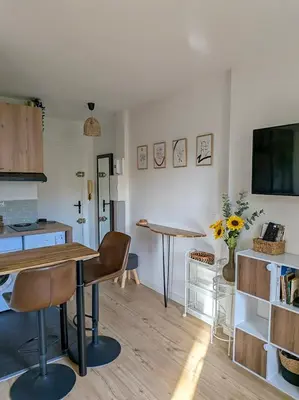 a living room with a table and a kitchen at Le Colibri - studio paisible et raffiné au sud d'Aix in Aix-en-Provence