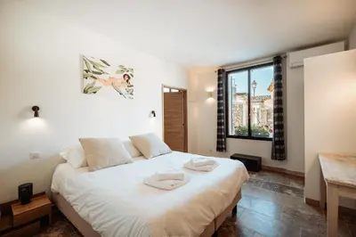 a bedroom with a large white bed with a window at La Source Blanche in Gargas