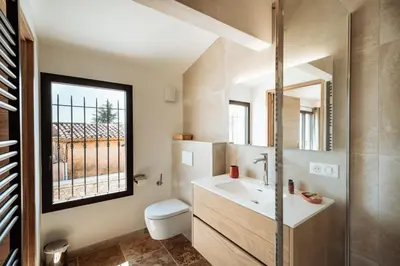 a bathroom with a sink and a toilet and a window at La Source Blanche in Gargas