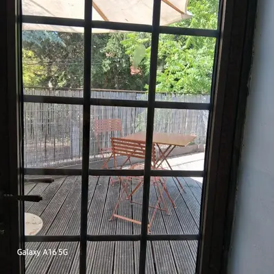 a view of a table and a bench through a window at gîtes carita in Cabannes