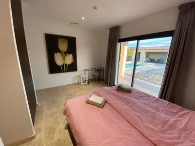 a bedroom with a large bed and a large window at Villa with pool in Provence bij de Mont Ventoux in Blauvac