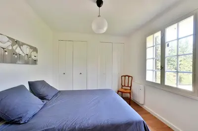 a bedroom with a blue bed and a chair at Villa Marie-Rose in Saint-Didier