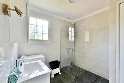 a white bathroom with a shower and a sink at Villa Marie-Rose in Saint-Didier