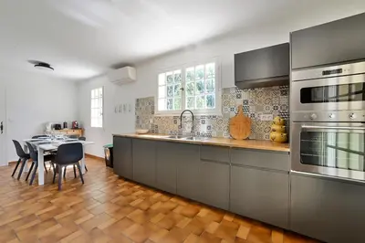 a kitchen with stainless steel appliances and a table at Villa Marie-Rose in Saint-Didier