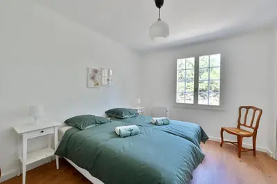 a bedroom with a bed with a desk and a chair at Villa Marie-Rose in Saint-Didier