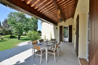 a patio with a table and chairs on a patio at Villa Marie-Rose in Saint-Didier
