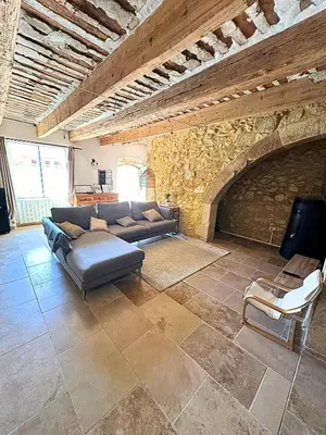 a living room with a couch and a stone fireplace at Mas Bourbon in Cavaillon