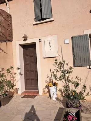 a building with a door and flowers in front of it at alize gîte en Provence in Jonquerettes