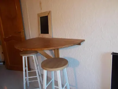 a table and two stools in front of a wall at alize gîte en Provence in Jonquerettes