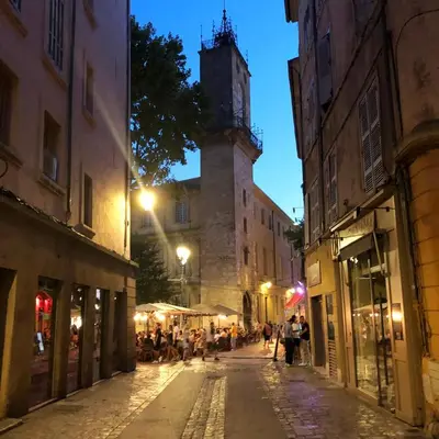 an empty street at night with a clock tower at Appart de charme CLIM 37m2 T1 Hôtel de ville in Aix-en-Provence