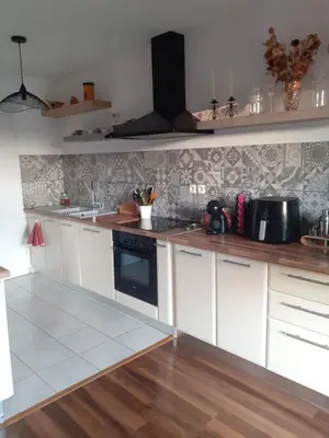 a kitchen with white cabinets and a black stove at Bichette in Cavaillon