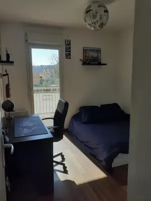 a bedroom with a bed and a desk with a laptop at Bichette in Cavaillon