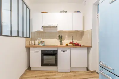 a kitchen with white cabinets and a counter top at T3 proche cardeurs clim centre ville in Aix-en-Provence