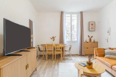 a living room with a television and a table at T3 proche cardeurs clim centre ville in Aix-en-Provence