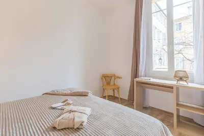 a bedroom with a bed with a desk and a window at T3 proche cardeurs clim centre ville in Aix-en-Provence