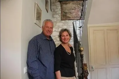 a man and a woman standing next to a wall at Gîte une treille en provence in Saint-Didier
