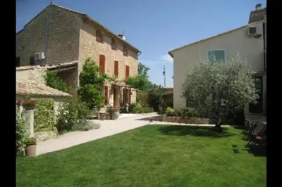 a large yard with a building and a grassy yard at Gîte une treille en provence in Saint-Didier
