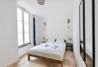 a white bedroom with a bed and a mirror at Suite Bleu d'Azur - Hypercentre - Wifi in Apt