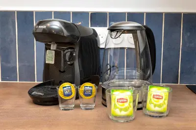 a coffee maker and two glasses on a counter at Suite Bleu d'Azur - Hypercentre - Wifi in Apt
