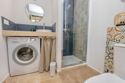 a bathroom with a washing machine and a shower at Suite Bleu d'Azur - Hypercentre - Wifi in Apt