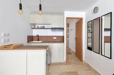 a kitchen with white cabinets and a counter top at Suite Terre d'Ocre - Hypercentre - Wifi in Apt