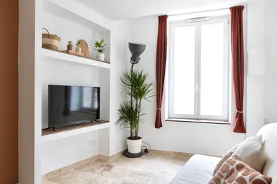 a living room with a flat screen tv on a wall at Suite Terre d'Ocre - Hypercentre - Wifi in Apt