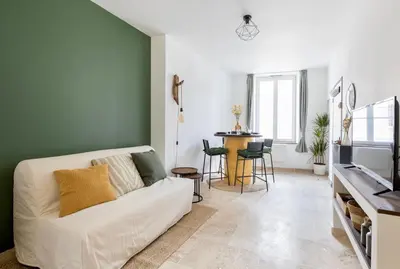 a living room with a white couch and a table at Suite Vert Provence - Hypercentre - Wifi in Apt