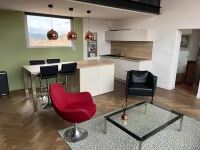 a kitchen with a red chair and a table at Aix-en-Provence, Centre ville quartier Mazarin, magnifique loft in Aix-en-Provence