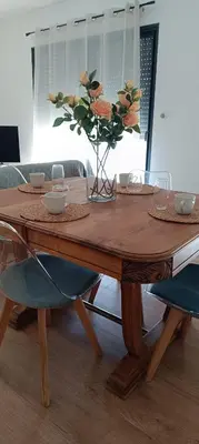 a wooden table with a vase of flowers on it at Le Refuge des Cigalons in Cavaillon