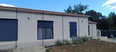 a white house with blue doors and a yard at Le Refuge des Cigalons in Cavaillon