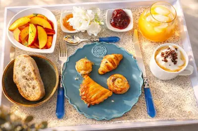 a table with a blue plate of breakfast foods and fruit at Bienvenue à la villa Bellavista in Pertuis