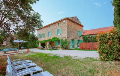 a group of lawn chairs in front of a building at Amazing Home In Lagnes in Lagnes