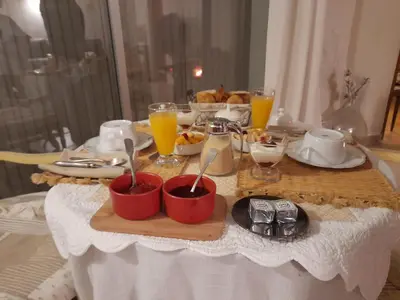 a table with a tray of breakfast food and orange juice at Tramontane chambre salon et piscine in Jonquerettes
