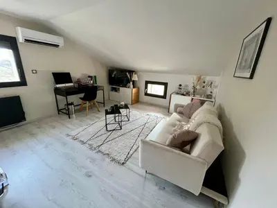 a living room with a white couch and a piano at Le Mas des platanes-piscine-gîte-Clim-parking in Monteux