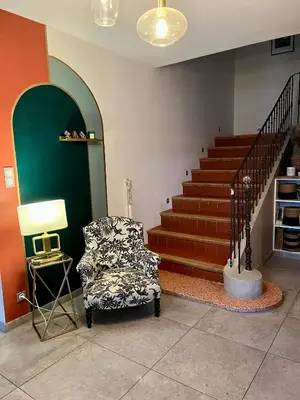 a living room with a chair and a staircase at Le Mas des platanes-piscine-gîte-Clim-parking in Monteux