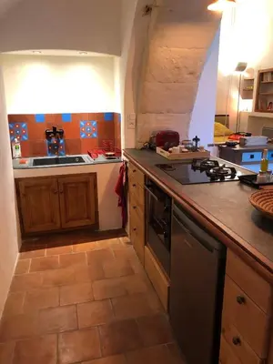 a kitchen with a counter and a stove top oven at studio au coeur de Lacoste in Lacoste