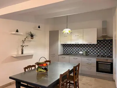a kitchen with a table with a bowl of fruit on it at Le Grand Hermas in Saint-Martin-de-Castillon