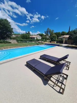 a pair of lounge chairs next to a swimming pool at Le Portail Vert in Villes-sur-Auzon