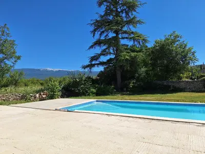 a swimming pool in a yard with a tree at Le Portail Vert in Villes-sur-Auzon