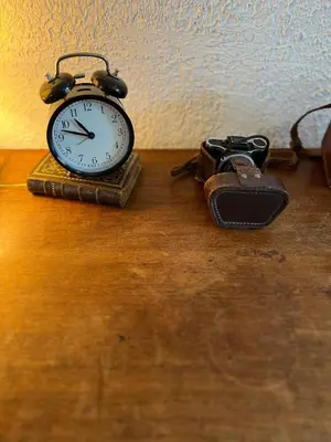 a clock sitting on top of a wooden table at Maison cosy en Provence Proche Golf Pont Royal in Alleins
