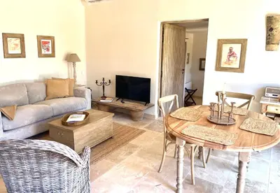 a living room with a table and a couch at Le Mas Natán in Gordes