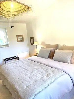 a bedroom with a large white bed with a chandelier at Le Mas Natán in Gordes