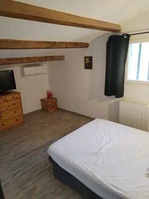 a bedroom with a white bed and a television at Close to Saint-Rémy-de-Provence in Eyragues