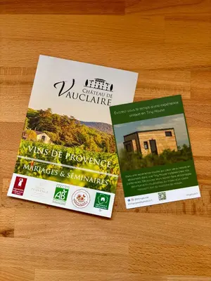 two books sitting on top of a wooden table at La Tiny House des Vignes du Château de Vauclaire in Meyrargues