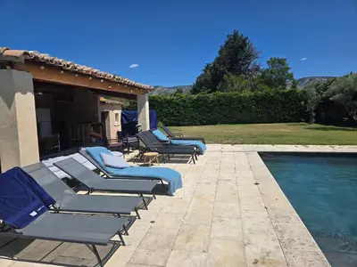 a row of lounge chairs next to a swimming pool at Luboregard in Cheval-Blanc