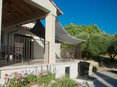 a porch with awning and a grill on a house at Sous le figuier in La Roque-sur-Pernes