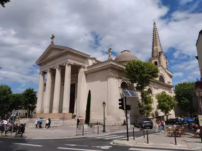 a large building with a steeple and a church at Maison de village rénovée au pied des alpilles in Mollégès