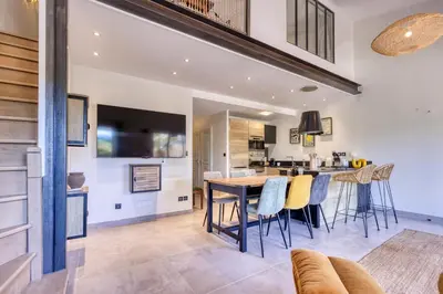 a kitchen and living room with a table and chairs at VILLA Isle sur la Sorgue in LʼIsle-sur-la-Sorgue